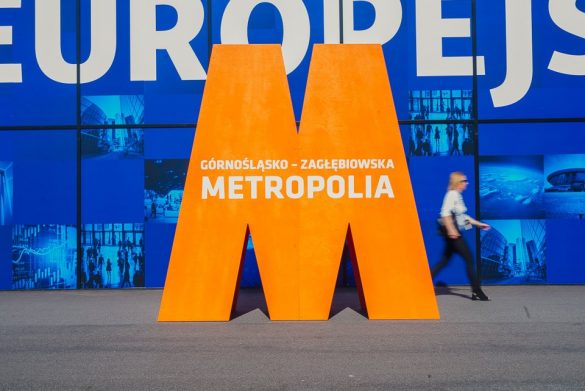 Duża litera M w kolorze pomarańczowym z napisem Górnośląsko-Zagłębiowska Metropolia