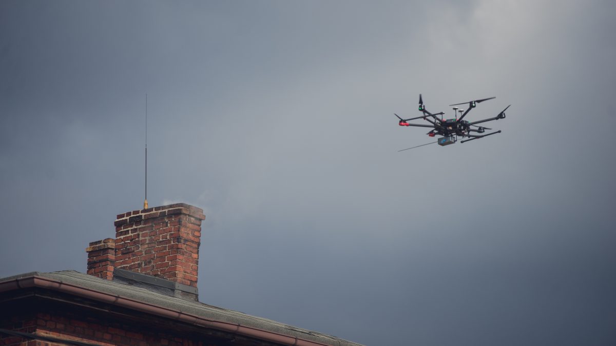 Dron przelatujący nad kominem domu prywatnego