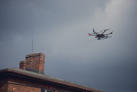 Dron przelatujący nad kominem domu prywatnego