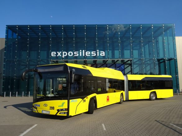 Żółty autobus, w tle oszklony budynek