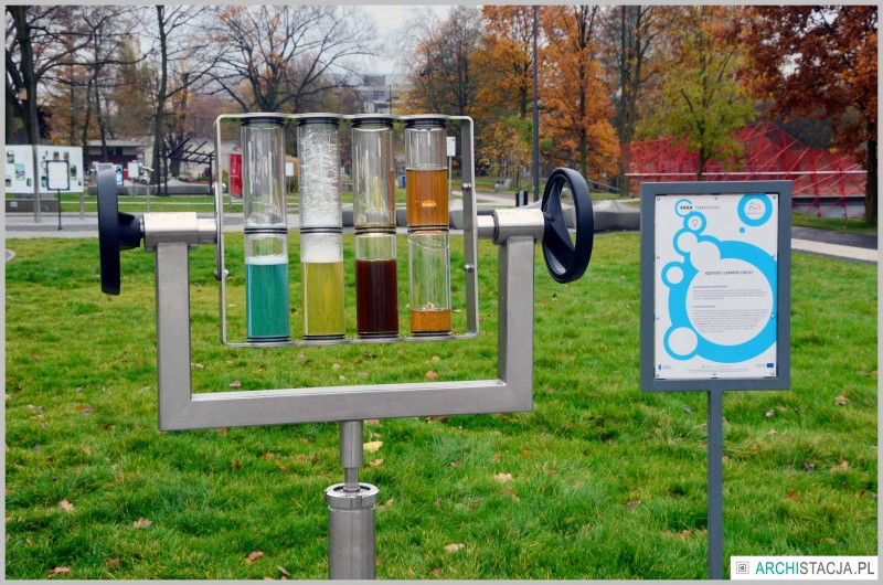 Szklane pojemniki z kolorowymi płynami na urządzeniu, którym można obracać, w tle park