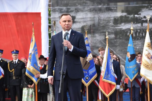 Prezydent Andrzej Duda przemawia. W tle poczty sztandarowe.