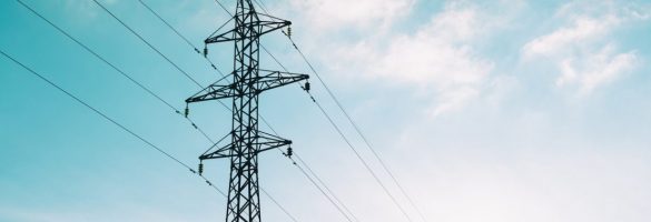 Słup z linią wysokiego napięcia na tle błękitnego nieba