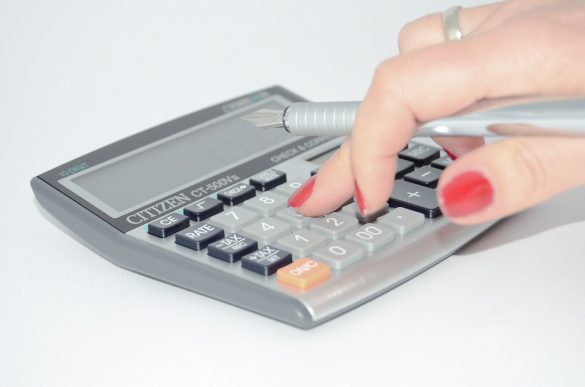 Zdjęcie kobiecej dłoni podczas liczenia na kalkulatorze