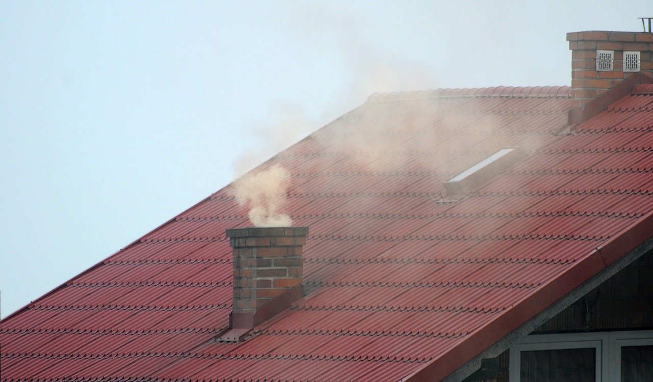 Komin domu jednorodzinnego z wydobywającym się dymem