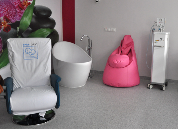 Widok na nowowyremontowane wnętrza porodówki - fotel, wanna oraz worek sako