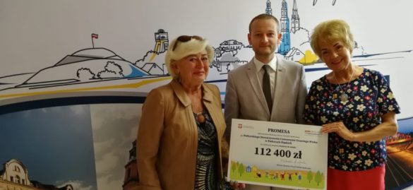 Przedstawiciele piekarskiego UTW pozują do zdjęcia z promesą