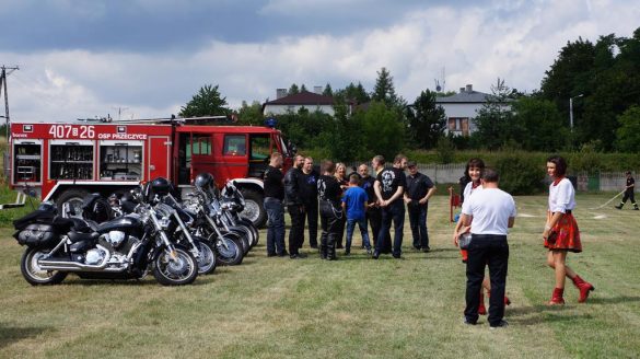 Grupa ludzi, wóz strażacki, motocykle