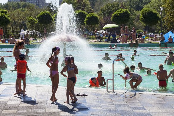 Dzieci podczas słonecznej pogody bawią się na otwartym basenie