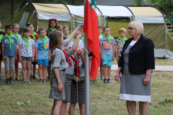 Dwie harcerki wieszające flagę Polski