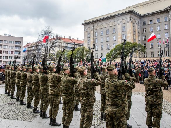 Żołnierze w mundurach prezentują się na Placu Piłsudskiego pod Urzędem Marszałkowskim