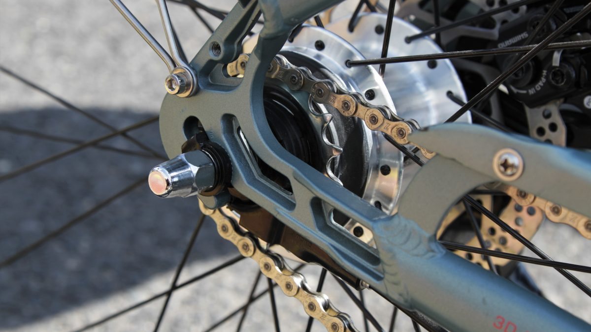 Zbliżenie na tylne koło rowerów z widocznymi szprychami, tylną zębatką oraz łańcuchem