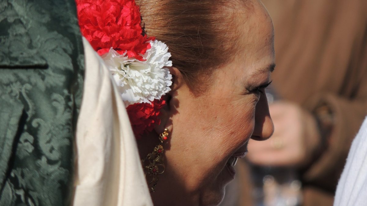 Kobieta z bialo-czerwonymi kwiatami we włosach