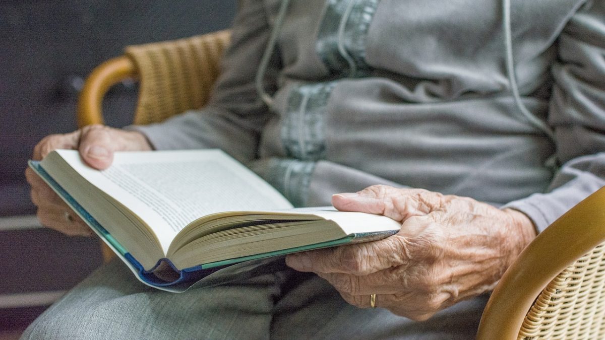 Starsza osoba czytająca książkę