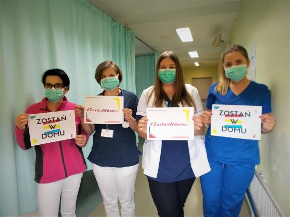 Personel szpitala z tabliczkami "Zostań w domu"