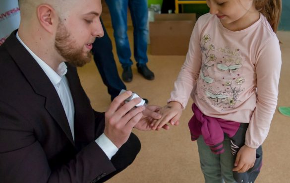 mężczyzna przybijający pieczątkę dziecku