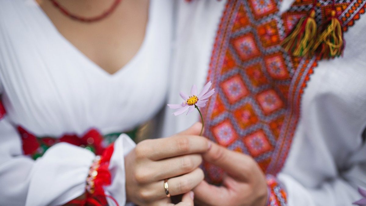 kobieta w stroju ludowym trzymająca kwiatek