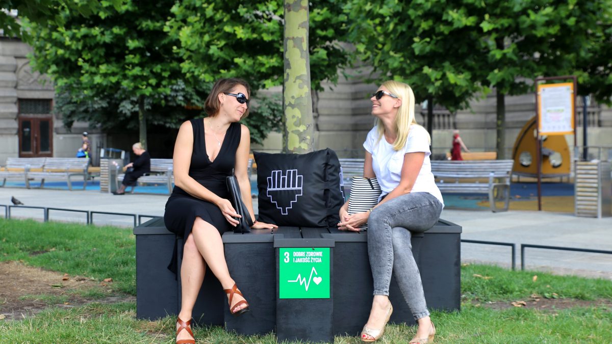 dwie kobiety siedzące w parku