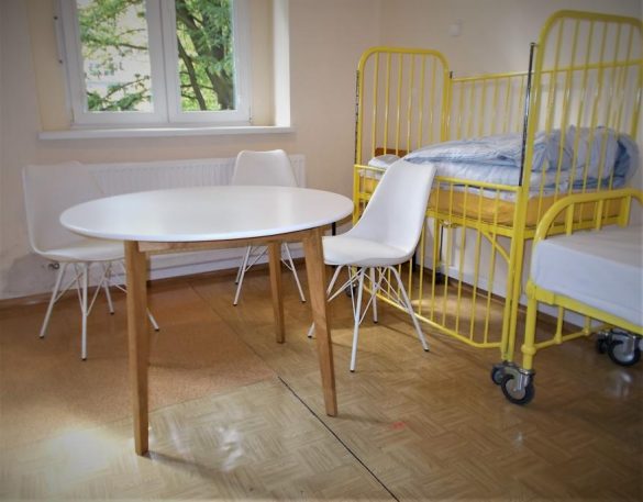 stół, krzesła i łóżko na sali szpitalnej