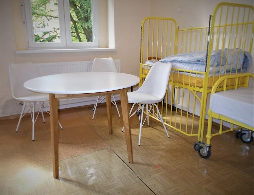 stół, krzesła i łóżko na sali szpitalnej