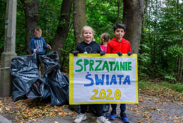 Dzieci trzymające planszę "Sprzątanie świata"