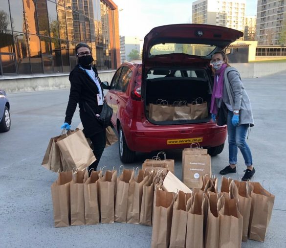 Dwie wolontariuszki pakują torby ze śniadaniem wielkanocnym do bagażniku samochodu