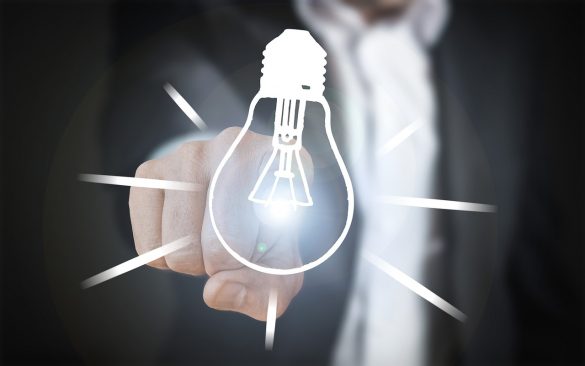 Mężczyzna w garniturze wskazujący na symbol żarówki