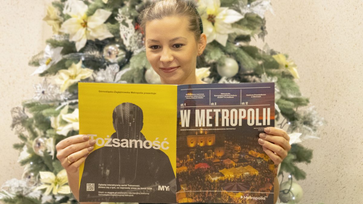 Młoda kobieta trzyma w rękach najnowsze wydanie Magazynu. W tle choinka
