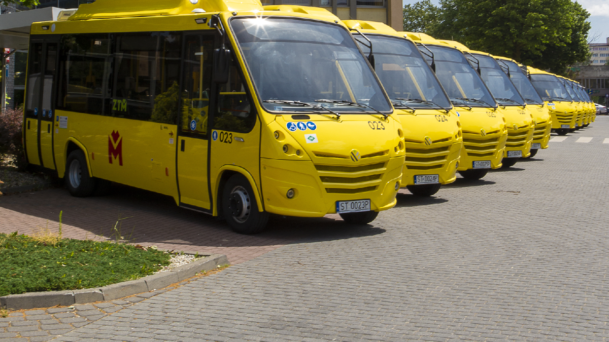 Żółte minibusy ustawione w rzędzie w zajezdni