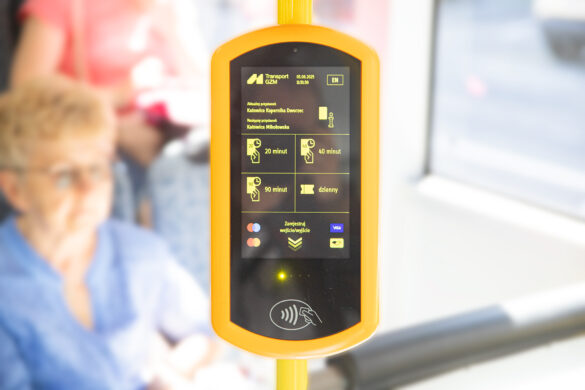 Widać mobilny, żółty biletomat w pojeździe komunikacji miejskiej GZM. Na ekranie wyświetlają się informacje o przystankach ("Katowice Superjednostka Dworzec", "Katowice Mikołowska") oraz opcje biletów czasowych (20, 40, 90 minut) i dziennego. Urządzenie obsługuje płatności zbliżeniowe kartami Visa, Mastercard i Maestro.