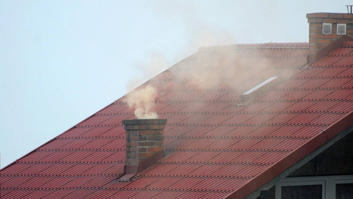 Dym wydobywający się z komina domku jednorodzinnego